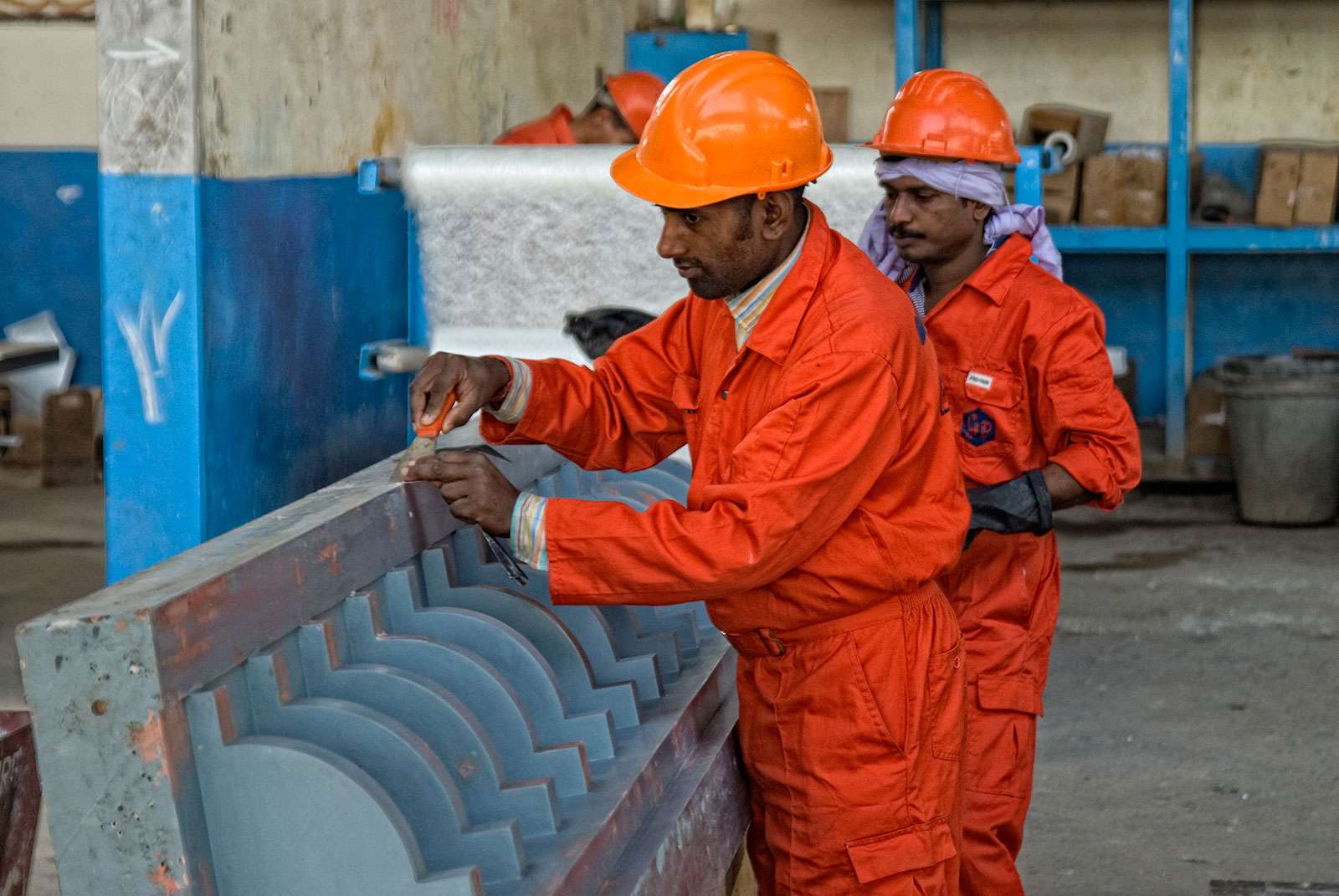 Skilled craftsmen manufacturing GRC decorative molding with precision handwork in production facility