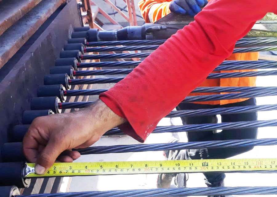 ps1 Worker measuring steel reinforcement cables for precast beams and columns during quality inspection.