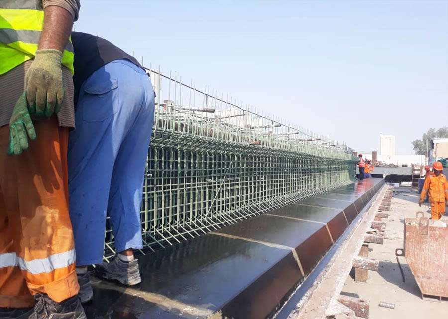 ps2 Workers assembling steel reinforcement for precast beams and columns at construction site